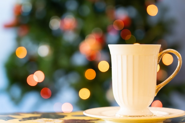 Vista della tazza di tè sulla tavola di legno con la luce di chrismas nell'evento di chrismas