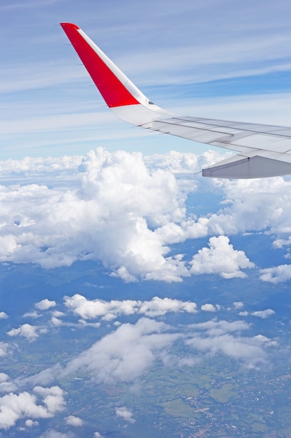 Vista della terra, del cielo, della nuvola e dell'ala dell'aeroplano dalla finestra