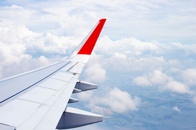 Vista della terra, della nuvola e dell'ala dell'aeroplano dalla finestra