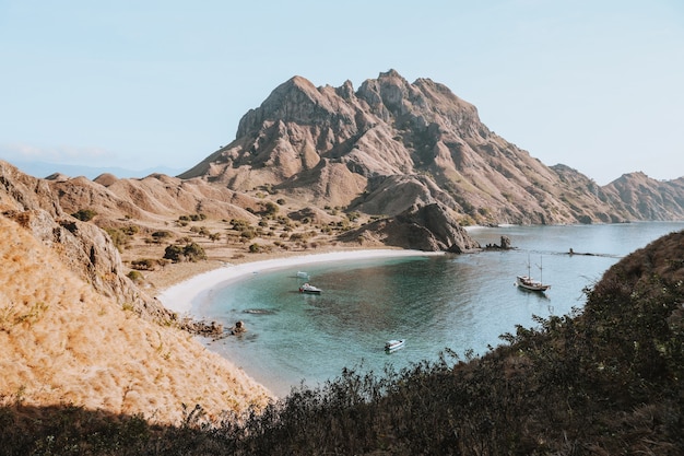 Vista delle colline e della costa e diverse barche a vela sull'isola di Padar