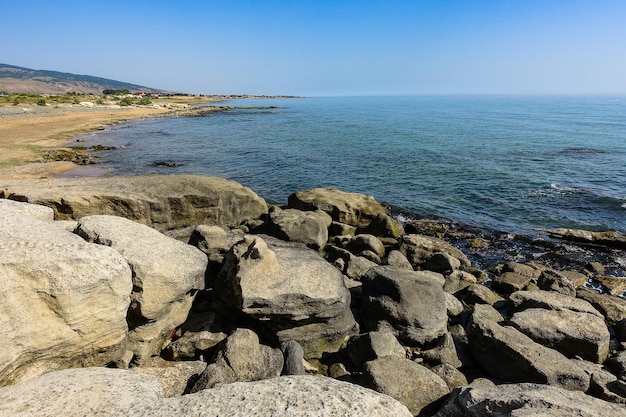 Vista delle onde del mare blu su una spiaggia rocciosa La linea dell'orizzonte Costa di arenaria del Mar Caspio Daghestan