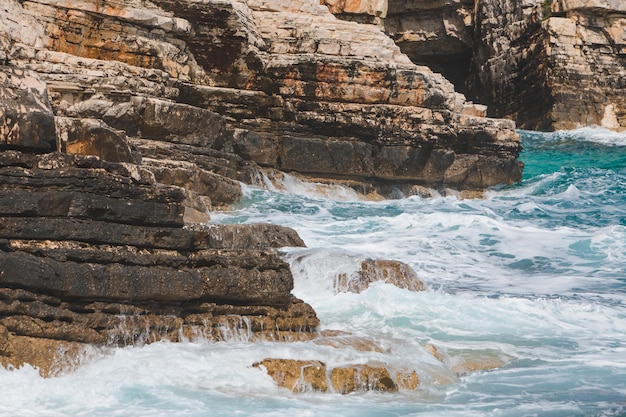 Vista delle onde rocciose del mare con schiuma bianca