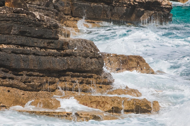 Vista delle onde rocciose del mare con spazio di copia in schiuma bianca