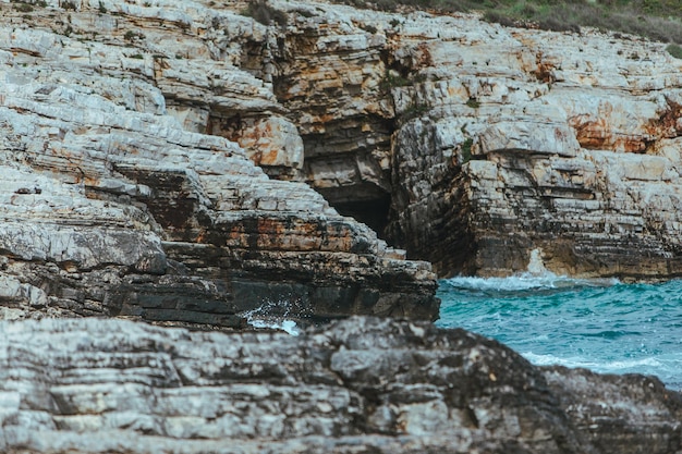 Vista delle onde rocciose sul litorale con schiuma bianca