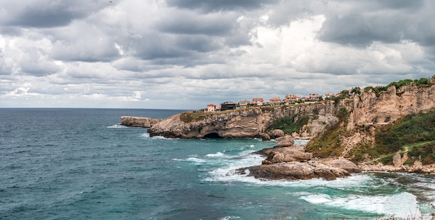 Vista delle scogliere che cadono nell'oceano mentre l'acqua turbina intorno alla costa rocciosa frastagliata