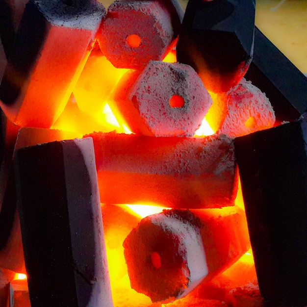 Vista di briquette di carbone esagonali sul fuoco che sta bruciando