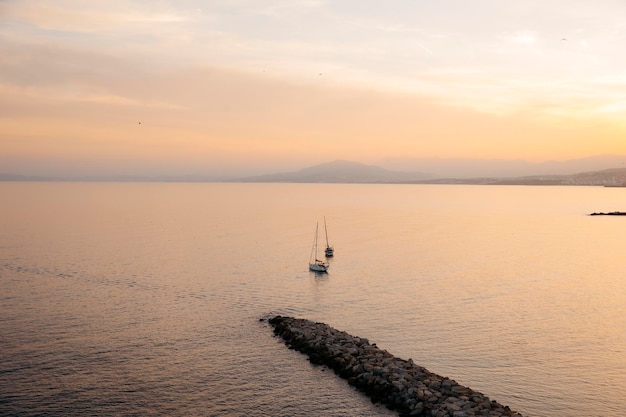 Vista di due barche a vela nella baia nord di Ceuta, di fronte alla spiaggia di chorrillo, al tramonto.