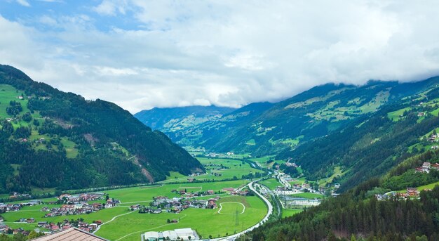 Vista di estate delle montagne delle alpi e villaggio nella valle, Austria