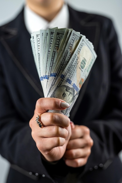 vista di mani femminili in giacca che mostrano un mucchio di banconote da un dollaro e festeggiano isolati su uno sfondo semplice denaro in mano donna d'affari signora capo