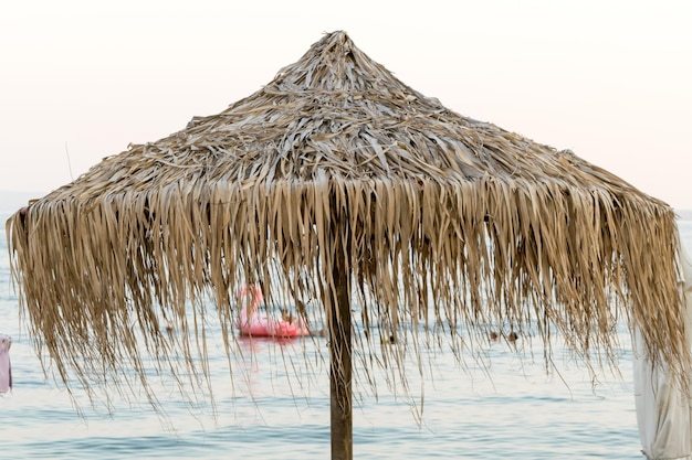 Vista di ombrelloni e lettini in legno su una spiaggia mediterranea