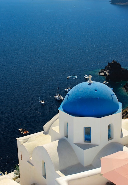 Vista di santorini della Grecia con la chiesa blu della cupola.