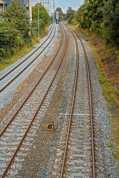 Vista di tre vecchi binari ferroviari che conducono fuori da una città in Danimarca Viaggiare e spostarsi in treno pubblico per andare al lavoro Rotaie in acciaio abbandonate per il trasporto di treni merci industria di importazione ed esportazione