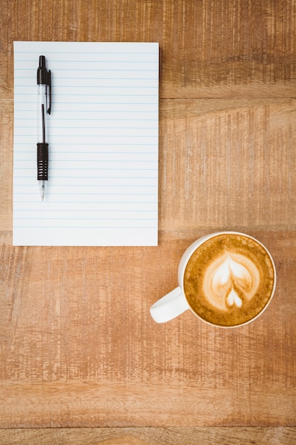 Vista di un cuore composto di caffè sullo scrittorio di legno