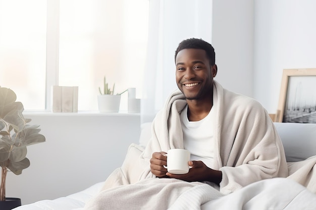 Vista di un giovane uomo afroamericano sorridente con una tazza di caffè a letto