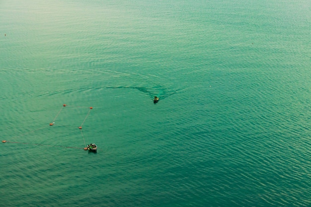 Vista di un motoscafo in movimento. barca con pescatori. I pescatori in barca controllano le reti. Trasporto d'acqua e tempo libero estivo.