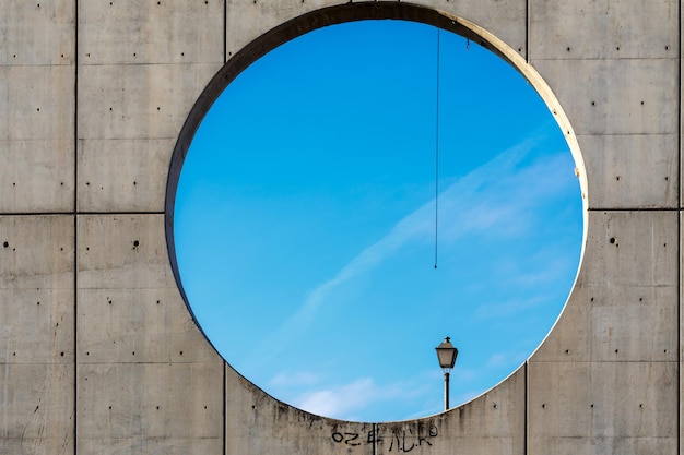 vista di una lampada attraverso una finestra circolare su una scultura monumentale a Madrid Spagna