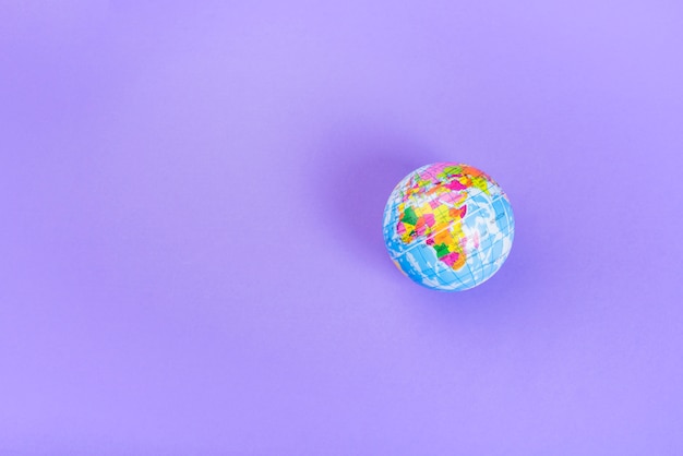 Vista elevata del piccolo globo di plastica su sfondo viola