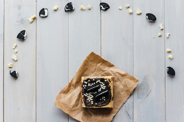 Vista elevata di pasticceria vicino a pezzi di cioccolato e biscotto che formano la forma della curva