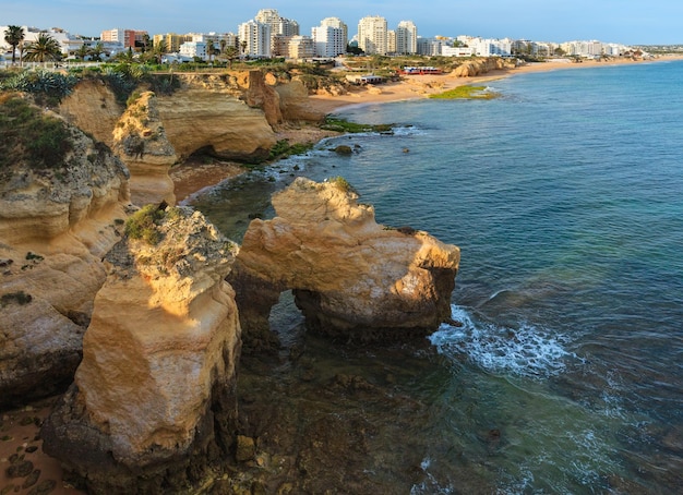 Vista estiva serale sulla spiaggia di Vale do Olival e sulla città di Portches. Paesaggio della costa atlantica (Lagoa, Algarve, Portogallo).