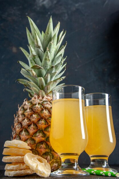 vista frontale ananas fresco fette di ananas secco succo di ananas in bicchieri su sfondo scuro