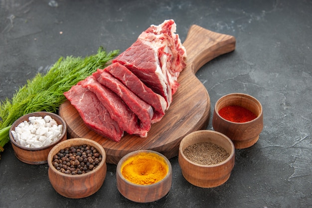 vista frontale carne fresca affettata con condimenti su sfondo scuro cena macellaio colore cibo animale carne barbecue pasto