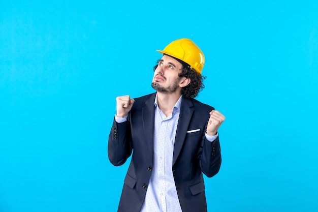 vista frontale costruttore maschio in casco giallo e tuta sullo sfondo blu costruttore costruzione architettura lavoro lavoro business design