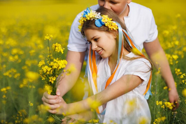 Vista frontale del fratello e della sorella dei bambini che camminano lontano lungo il sentiero con erba circondata da campi gialli