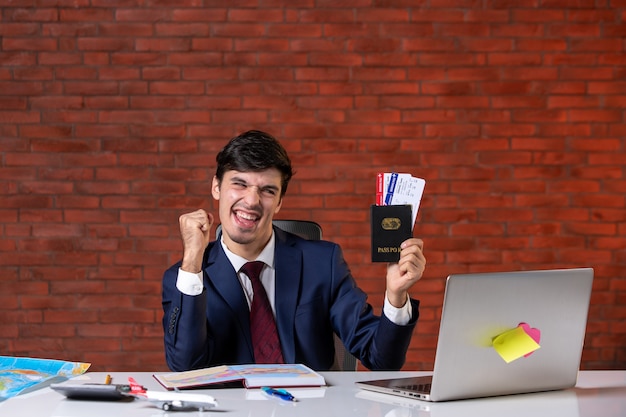 vista frontale del lavoratore di sesso maschile in tuta in possesso di biglietti e passaporto internazionale piano di lavoro appaltatore progetto aziendale occupazione aziendale turismo