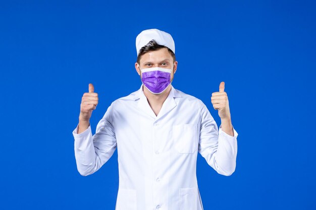 Vista frontale del medico maschio in tuta medica e maschera viola sull'azzurro