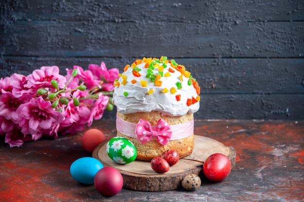 vista frontale deliziosa torta alla crema con frutta secca per pasqua su sfondo scuro colore pasqua etnica colorata vacanza ornata