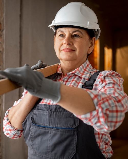 Vista frontale dell'operaio edile femminile con il cappello duro