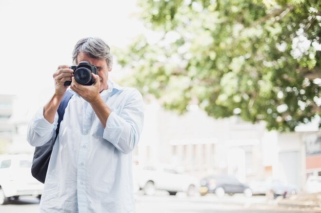 Vista frontale dell'uomo che esamina la macchina fotografica