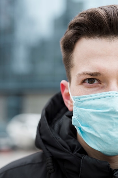 Vista frontale dell'uomo che indossa maschera medica nella città