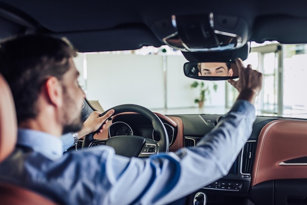 Vista frontale dell'uomo d'affari che regola lo specchietto retrovisore in auto