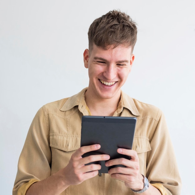 Vista frontale dell'uomo sorridente guardando tablet