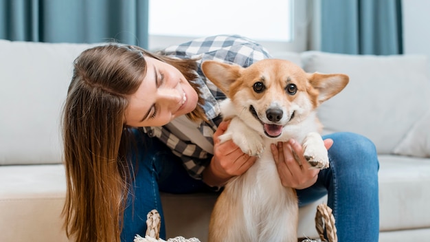 Vista frontale della donna che tiene il suo cane carino