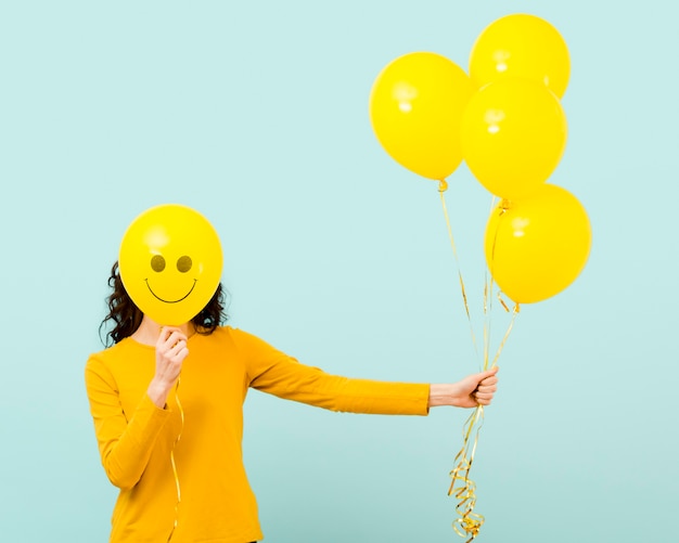 Vista frontale della donna con palloncini