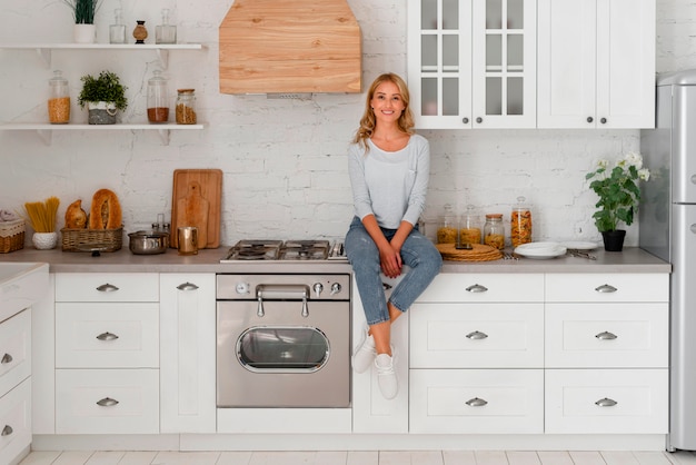 Vista frontale della donna sorridente in piedi in cucina