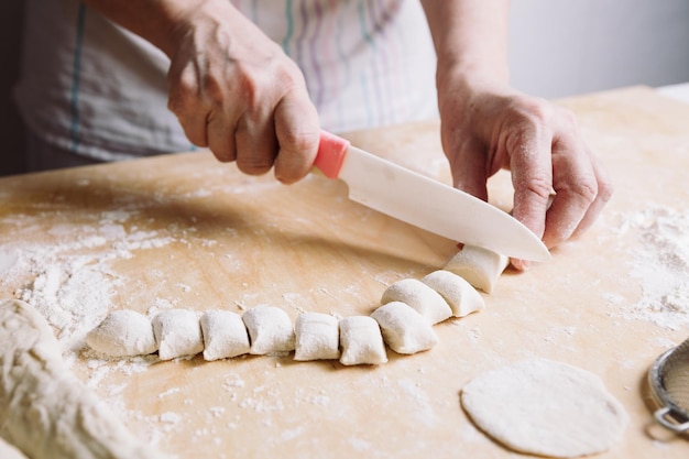 Vista frontale delle mani della donna che producono pasta per gnocchi di carne