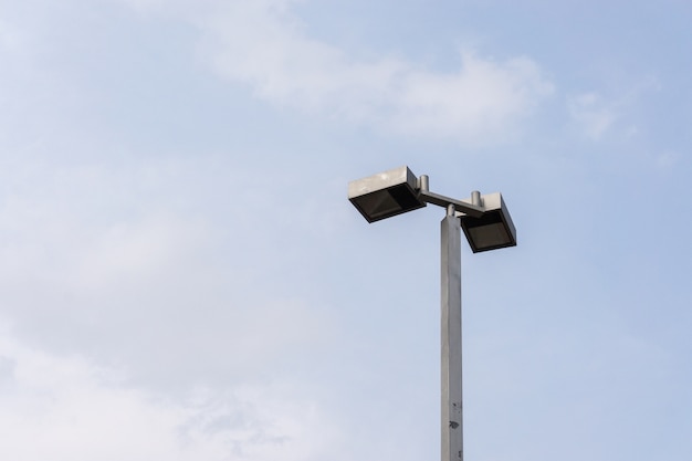 Vista frontale di elettricità dell&#39;iluminazione pubblica isolata con cielo blu, con lo spazio della copia