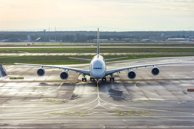 Vista frontale di un grande aeroplano sui binari dello sterzo e parcheggio in aeroporto dopo l'atterraggio