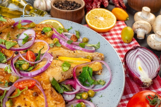 Vista frontale di una deliziosa cena piatto di pollo fritto con varie spezie e cibi garlics olio caduto bottiglia limone cipolle funghi kumquat