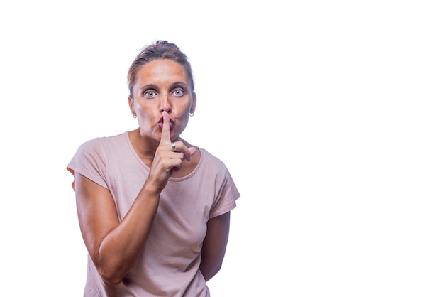 Vista frontale di una donna dagli occhi verdi che gesticola il silenzio mentre guarda la telecamera su uno sfondo bianco con spazio di copia.