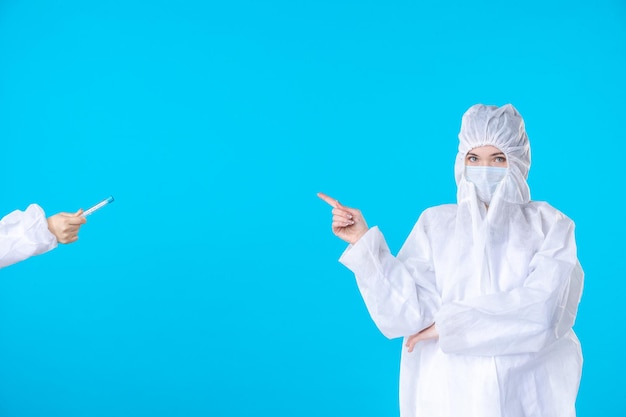 vista frontale dottoresse in tute protettive e maschere che prendono pallone sullo sfondo blu scienza della salute dell'ospedale medico covid- virus pandemico
