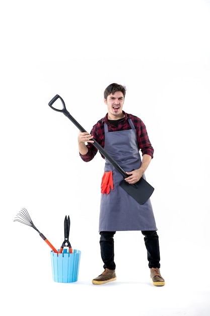 Vista frontale giardiniere maschio giocando sulla pala nera come una chitarra su sfondo bianco terreno uniforme lavoro albero giardino lavoro fiore terreno di scavo