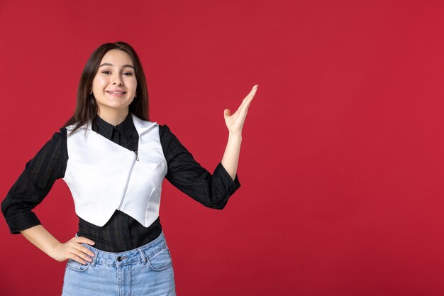 vista frontale giovane cameriera in uniforme che punta su sfondo rosso lavoratore colore lavoro lavoro ristorante cena serale dish