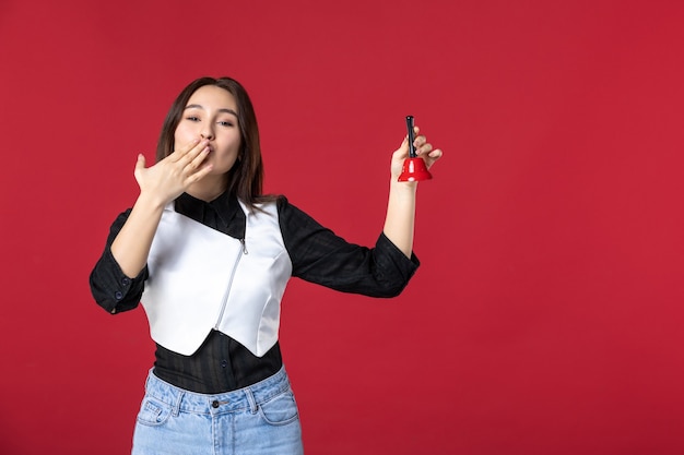 vista frontale giovane cameriera in uniforme con campanella su sfondo rosso donna cena lavoro sera lavoratore bellezza ristorante