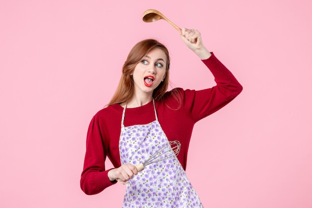vista frontale, giovane casalinga, presa a terra, frusta, e, cucchiaio di legno, su, sfondo rosa, cucinare, uniforme, orizzontale, torta, cucina, professione, cake