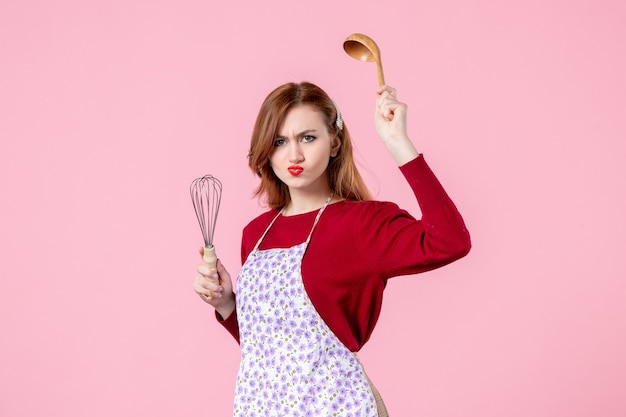 vista frontale, giovane casalinga, presa a terra, frusta, e, cucchiaio di legno, su, sfondo rosa, cucinare, uniforme, torta, cucina, professione, donna, cake