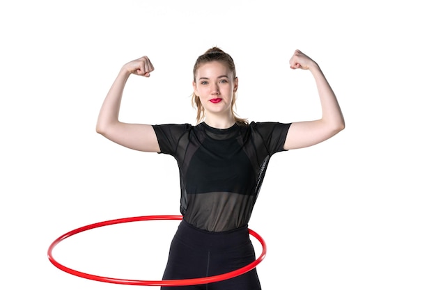 vista frontale giovane donna che lavora con hula hoop rosso che si flette su sfondo bianco atleta sport donna salute colore del corpo yoga